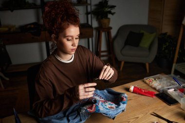 Yetenekli genç bir kadın, yaratıcı aletlerle çevrili DIY projesi üzerinde çalışıyor..