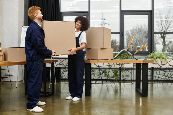 A happy couple packs and unpacks moving boxes, emphasizing teamwork in a modern office.