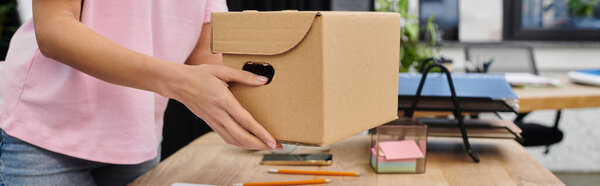 woman carefully packs items into a cardboard box during a contemporary moving process