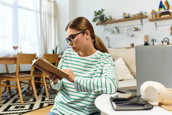 Rahat bir yaşam alanı büyüleyici bir kitaba gömülmüş genç bir kadını gösteriyor..