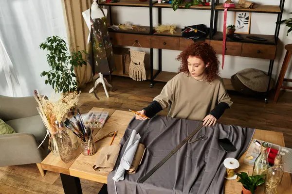 Genç bir kadın evdeki el işi projesi için ustalıkla kumaş kesiyor..