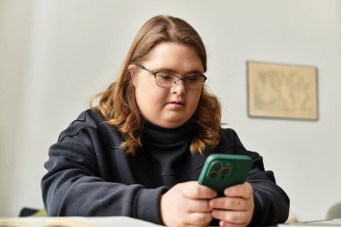 Rahat bir oda, Down sendromlu genç bir kadının telefonuyla etkileşime girmesiyle uğulduyor..