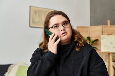 Down sendromlu genç bir kadın evde dinlenirken anlamlı bir telefon görüşmesi yapıyor..