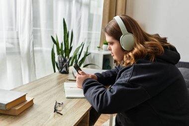 Rahat bir anda Down sendromlu genç bir kadın telefonuyla evde sakin bir şekilde meşgul oluyor..