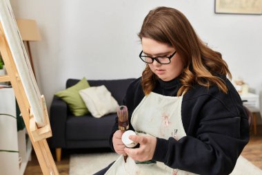 Genç bir kadın evde kendine güvenerek sanat yaratıyor, yaratıcılığını malzemelerle gösteriyor..