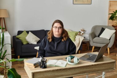 Down sendromlu genç bir kadın evdeki rahat masasında güven içinde oturuyor..