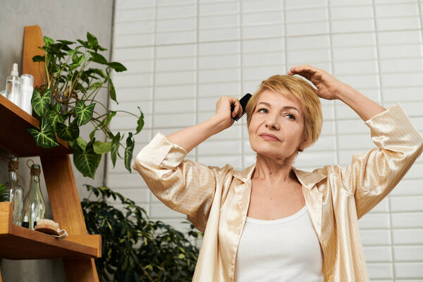 Старшая женщина стилей ее короткие волосы с осторожностью, источая уверенность и изящество в спокойной обстановке.