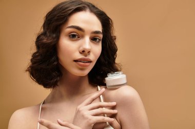 Diş teli takan güzel genç bir kadın güneşli bir stüdyoda cilt bakımını gösteriyor..