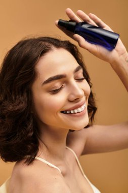 Diş teli takan genç bir kadın stüdyo ortamında cilt bakımını mutlulukla gösterir..