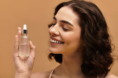 Modern bir stüdyoda gülümserken cilt bakımını sergileyen güzel bir genç kadın..