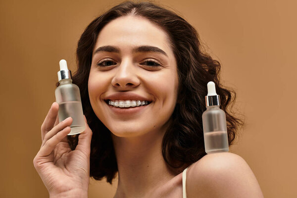 Красивая молодая женщина демонстрирует свою рутину по уходу за кожей, улыбаясь в яркой студии.