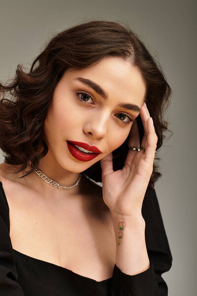 Красивая молодая женщина с очаровательной улыбкой подчеркивает свои брекеты и завораживающие красные губы.