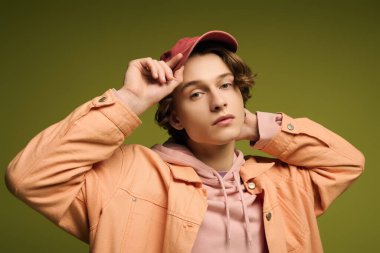 Pembe kapüşonlu ve turuncu ceketli şık bir genç modern trendleri özgüvenle sunar..
