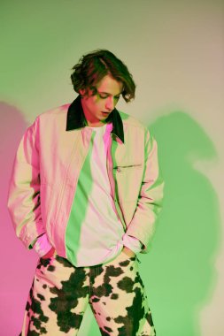 Moda elbiseli genç bir adam renkli ışıklar altında poz verirken karizma yayar..