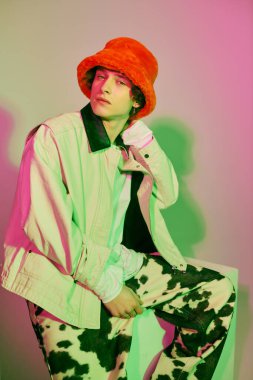 Kendine güvenen genç adam modern gençlik kültürünü renkli moda içinde sergiliyor..