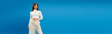 Genç Asyalı kadın canlı mavi bir arka plana karşı kendine güvenen modaya uygun modeller..