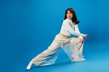 Şık, genç Asyalı bir kadın, kendine güvenen bir şekilde şık bir şekilde poz veriyor..