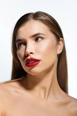 Göz kamaştırıcı kırmızı dudakları olan genç bir kadın parlak ışıkta bir anlık yansımanın tadını çıkarıyor..