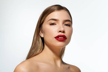 Zarif bir makyaj ve sanatsal bir sunum için çarpıcı bir poz sergileyen güzel bir genç kadın..