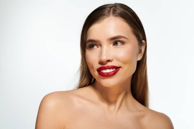 Genç bir kadın çarpıcı gülüşünü, kusursuz makyajını, kendine güvenini ve çekiciliğini sergiliyor..