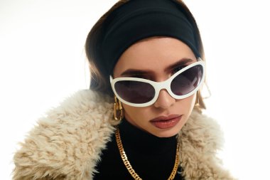 Kendine güvenen genç bir kadın modaya uygun güneş gözlükleri ve şık aksesuarlarıyla eşsiz tarzını sergiliyor..