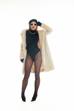 Genç bir kadın şık bir kıyafete güveniyor, zarafeti çağdaş yeteneklerle harmanlıyor..