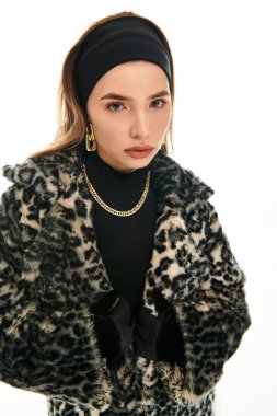 Güzel genç bir kadın moda anlayışını şık bir kürk mantoyla sergiliyor..