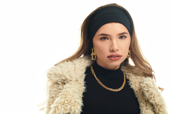 A young woman confidently models her trendy outfit against a vibrant backdrop.
