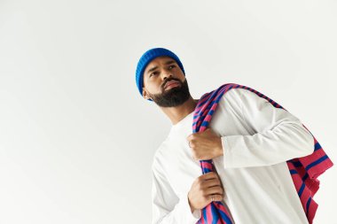 Kendine güvenen bir adam modern tarzı parlak bir bereyle ve şık bir yerde şık bir eşarpla sergiler..