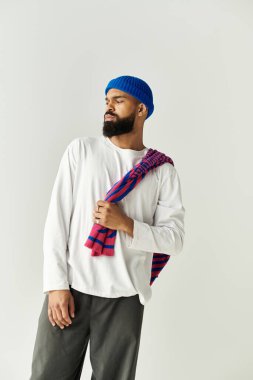 Modern moda ortamında kendine güvenen genç bir adam eşsiz tarzını sergiliyor..