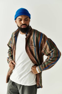 Şık bir genç adam, parlak ve havalı bir stüdyo ortamında şık kıyafetler sergiliyor..