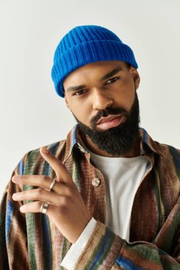 Bereli yakışıklı genç adam modern bir iç mekan ortamında cesur moda anlayışını sergiliyor..