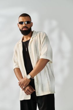 Yakışıklı genç adam kendine has tarzını sergiliyor. Parlak bir mekanda şık bir kıyafet giyiyor..