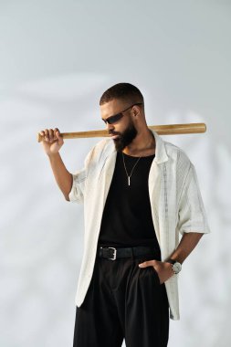 Yakışıklı genç bir adam elinde beyzbol sopasıyla moda anlayışını sergiliyor..