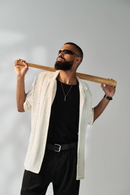 Şık bir genç adam, güvenli bir şekilde omzunun üzerinde tahta bir kalas tutuyor ve karizma yayıyor..