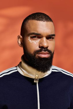 Kendinden emin genç adam canlı bir arkaplan karşısında modern tarz ve sanatsal özellikler sergiliyor..