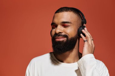 Yakışıklı adam müzik dinlerken keyifle gülümsüyor, etrafında canlı bir atmosfer yaratıyor..