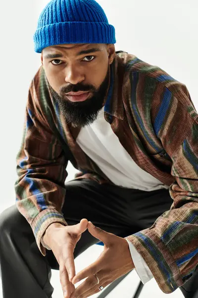 Şık bir genç adam moda anlayışını parlak bir stüdyoda renkli bir kıyafetle sunar..