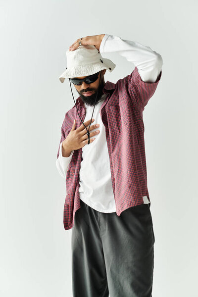 Confident man in trendy attire blends style and charisma against a clean backdrop.