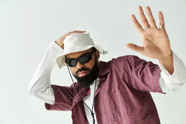 Kendine güveni olan genç adam, modaya uygun kıyafetleri ve kapalı mekanlarda eşsiz aksesuarlarıyla bireyselliğini ifade ediyor.