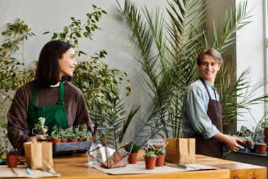 Yaratıcı çift, verimli bitkiler ve yaratıcı enerjiyle çevrili canlı bir sanat stüdyosunda neşe içinde eğleniyor.