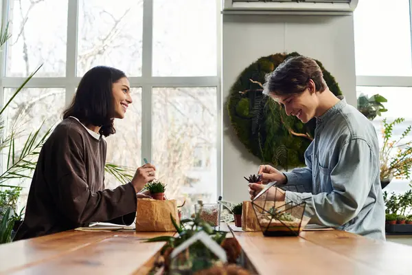 Genç çift, canlı bitkiler ve sanatın ortasında neşeyle minyatür bahçeler yaratıyor..