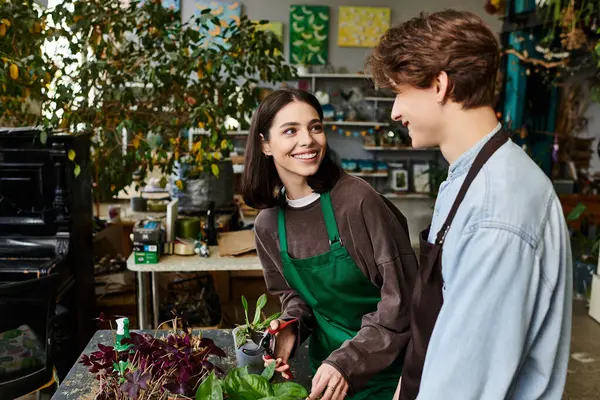 Sevgi dolu bir çift, sanatsal bir ortamda bitki yetiştirirken gülümseme ve fikir alışverişinde bulunur..