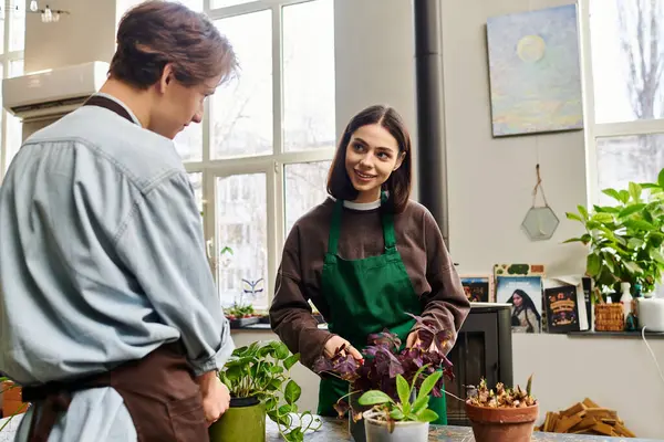 Genç çift, stüdyoda canlı bitkilerle ilgilenirken fikir alışverişinde bulunuyor..