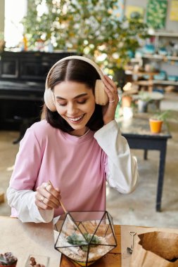 Genç bir sanatçı bitki akaryumu üzerinde çalışırken, müzik dinlerken yaratıcılığa daldı..