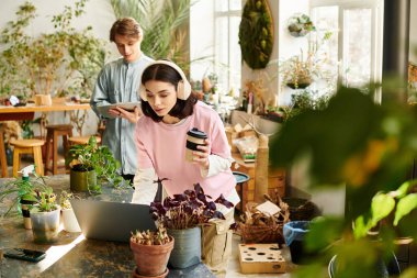 İki yaratıcı gelişmekte olan, bitki dolu bir stüdyoda sanat faaliyetlerine girişiyor..