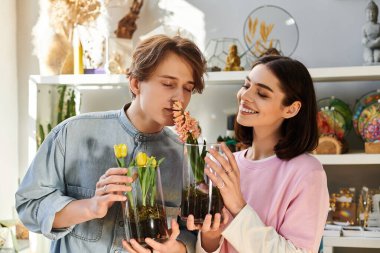 Genç çift, parlak bir sanat stüdyosundaki çiçek aranjmanlarının keyfini çıkarıyor..