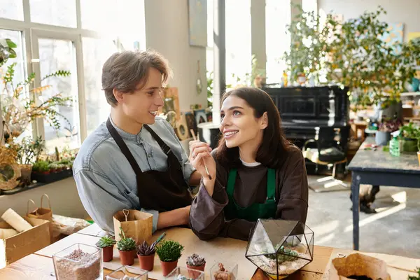 Yaratıcı çift, canlı bir sanat stüdyosunda proje üzerinde çalışırken kahkahalarını ve fikirlerini paylaşıyor..