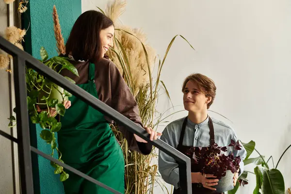 İki genç sanatçı sevinçle bitkilerin arasında hayat dolu, ilham verici bir atmosfer yaratıyor..