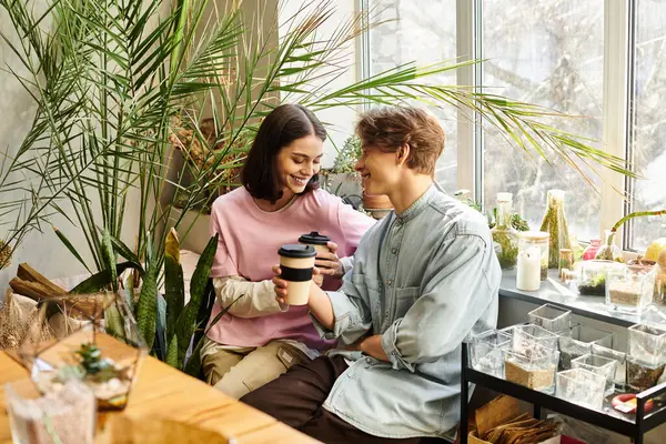 Yaratıcı çift yeşil, yaratıcı bir yerde kahve içerken sohbet ediyorlar..